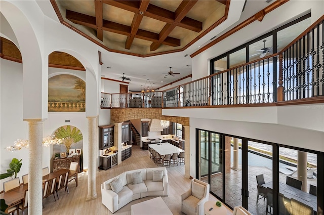 living room featuring light wood-type flooring, beam ceiling, a towering ceiling, and coffered ceiling