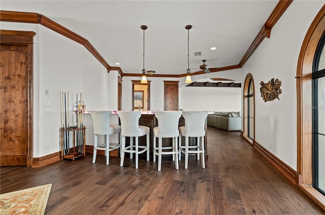 kitchen with dark hardwood / wood-style floors, ceiling fan, ornamental molding, decorative light fixtures, and kitchen peninsula