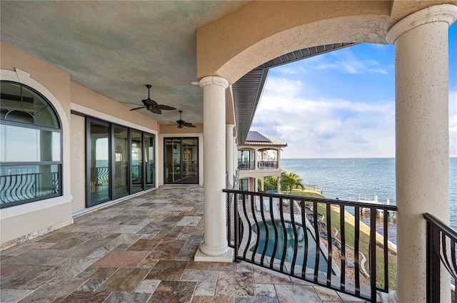 balcony featuring ceiling fan and a water view