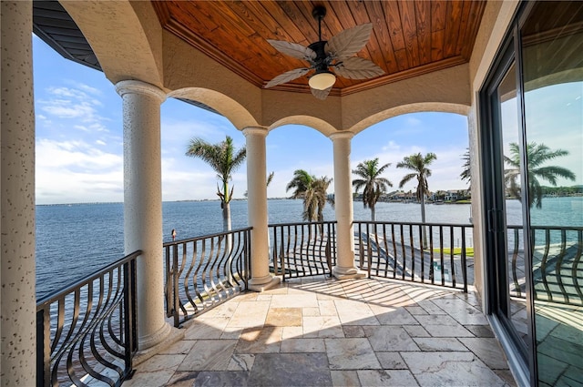 view of patio / terrace with a water view, ceiling fan, and a balcony