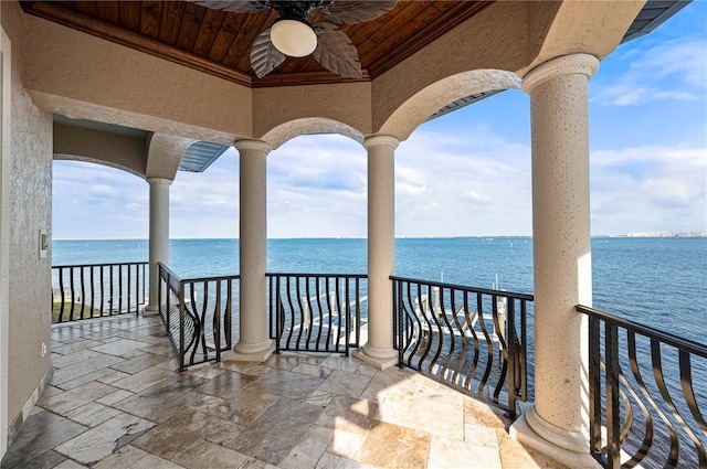 balcony with ceiling fan and a water view