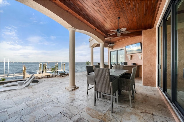 view of patio / terrace with ceiling fan and a boat dock