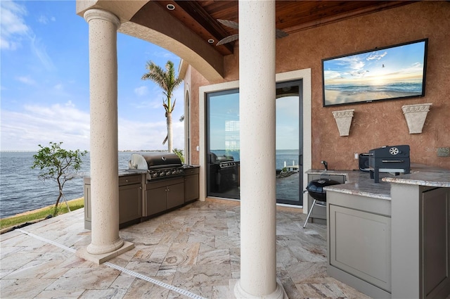 view of patio / terrace featuring area for grilling, a grill, and a water view