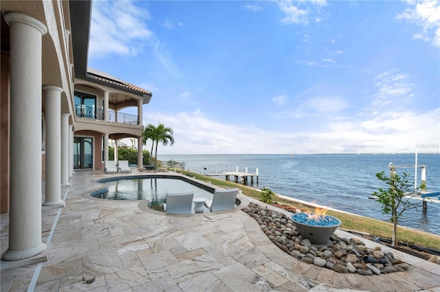 view of pool featuring a water view and a patio