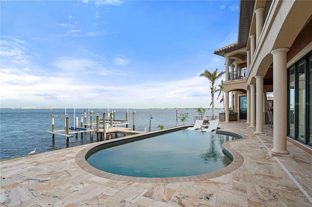 view of pool with a water view, a patio, and a boat dock