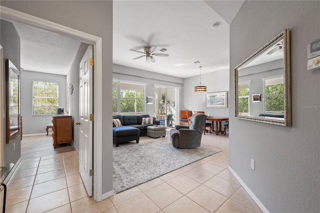 tiled living room featuring plenty of natural light, ceiling fan, and a textured ceiling