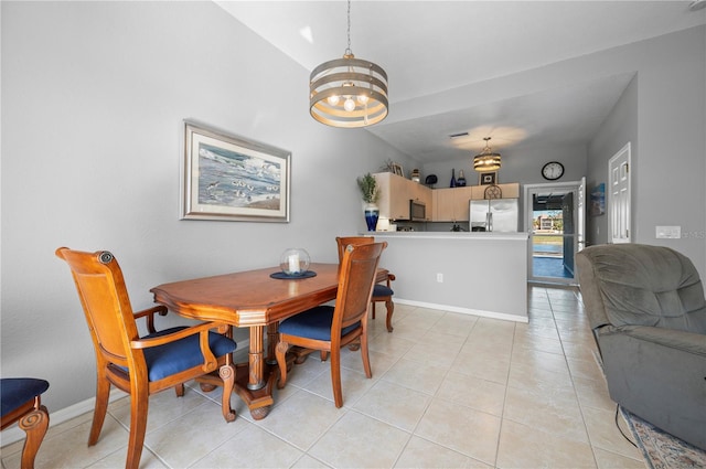 tiled dining room with an inviting chandelier