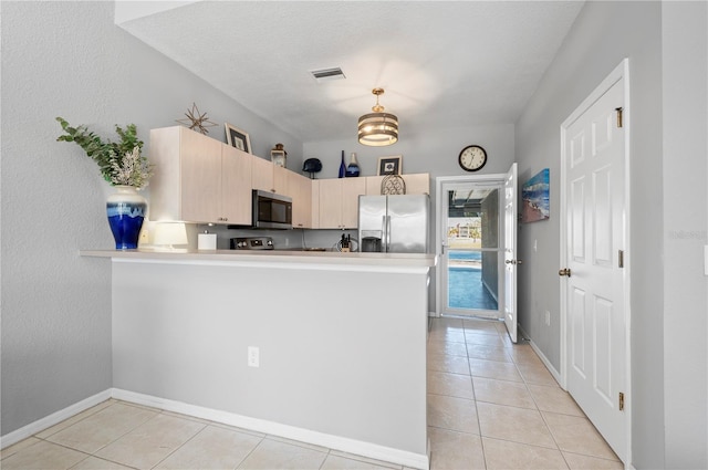 kitchen with light brown cabinets, light tile patterned floors, a textured ceiling, appliances with stainless steel finishes, and kitchen peninsula