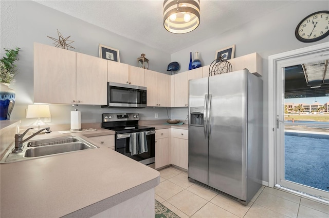 kitchen featuring sink, a textured ceiling, light brown cabinetry, light tile patterned flooring, and appliances with stainless steel finishes