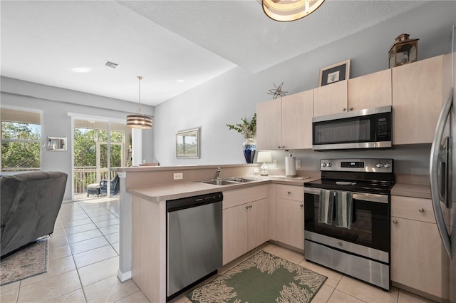 kitchen featuring decorative light fixtures, light tile patterned flooring, kitchen peninsula, and stainless steel appliances