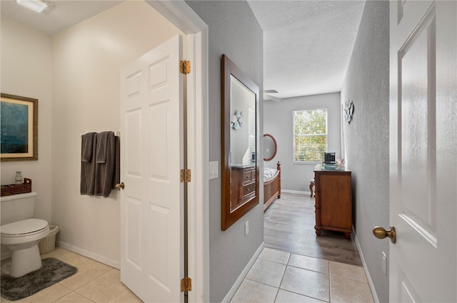 bathroom featuring tile patterned flooring, toilet, and a textured ceiling