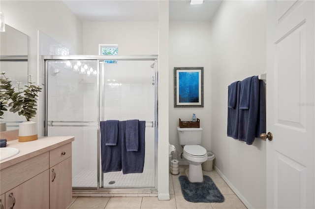 bathroom featuring tile patterned floors, vanity, a shower with shower door, and toilet