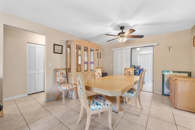 tiled dining room featuring a textured ceiling and ceiling fan