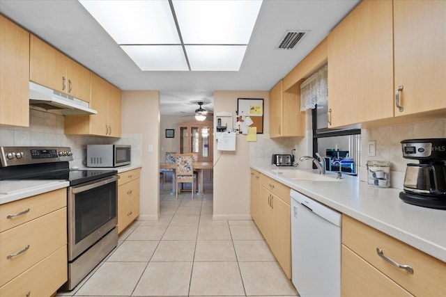 kitchen with decorative backsplash, stainless steel appliances, sink, light brown cabinets, and light tile patterned floors