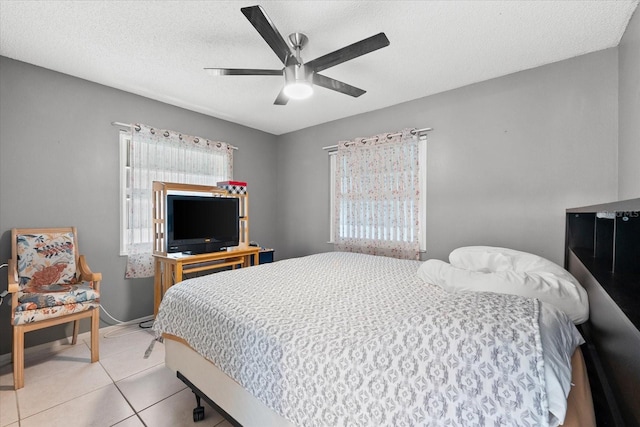 bedroom with multiple windows, a textured ceiling, ceiling fan, and light tile patterned flooring