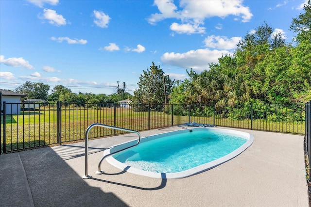 view of pool featuring a lawn and a patio