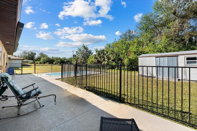 view of patio / terrace featuring a fenced in pool and a storage shed