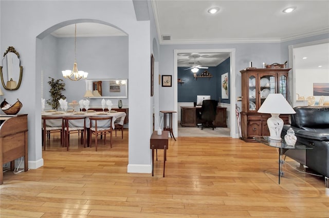 hall featuring a notable chandelier, ornamental molding, and light hardwood / wood-style flooring