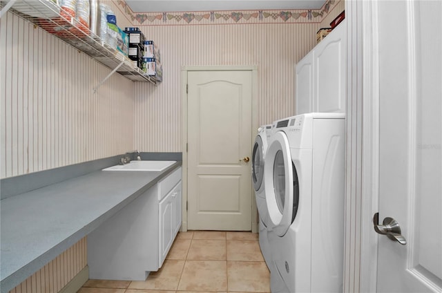 laundry room featuring separate washer and dryer, sink, light tile patterned floors, and cabinets