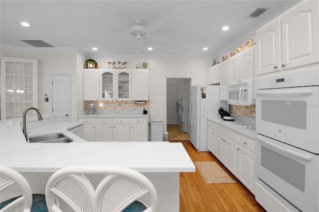 kitchen with white cabinets, white appliances, sink, and ornamental molding