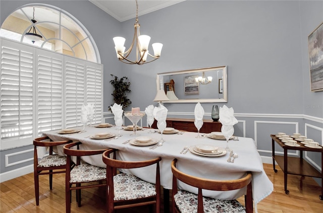 dining space featuring crown molding, hardwood / wood-style floors, and a chandelier