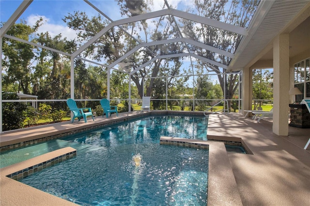 view of pool with glass enclosure and a patio area