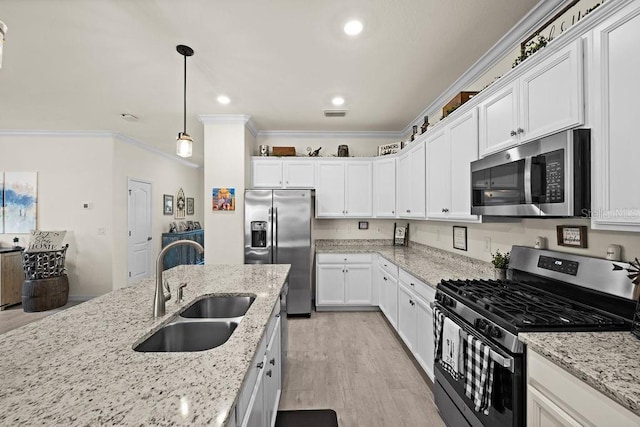 kitchen featuring light stone countertops, appliances with stainless steel finishes, sink, white cabinets, and hanging light fixtures