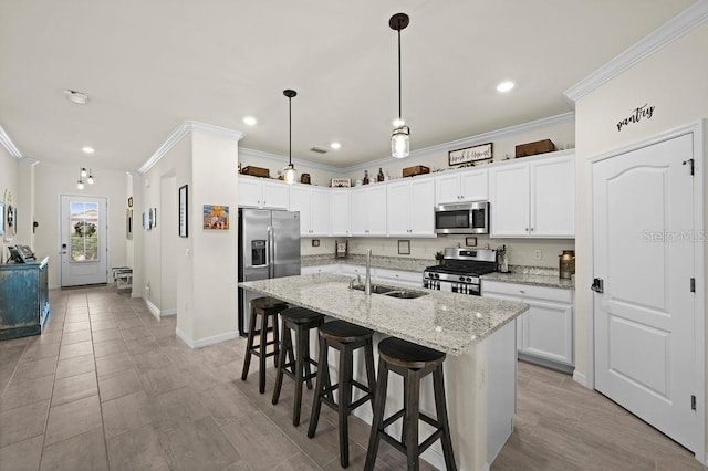 kitchen with pendant lighting, a kitchen island with sink, sink, light stone counters, and stainless steel appliances