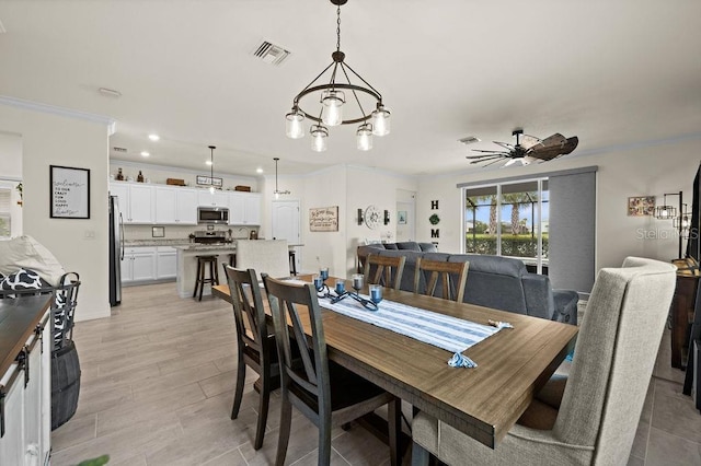 dining area with ceiling fan with notable chandelier and ornamental molding