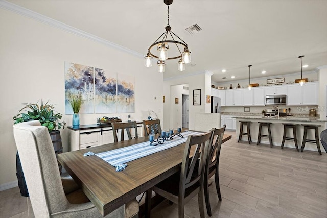 dining space with crown molding and an inviting chandelier