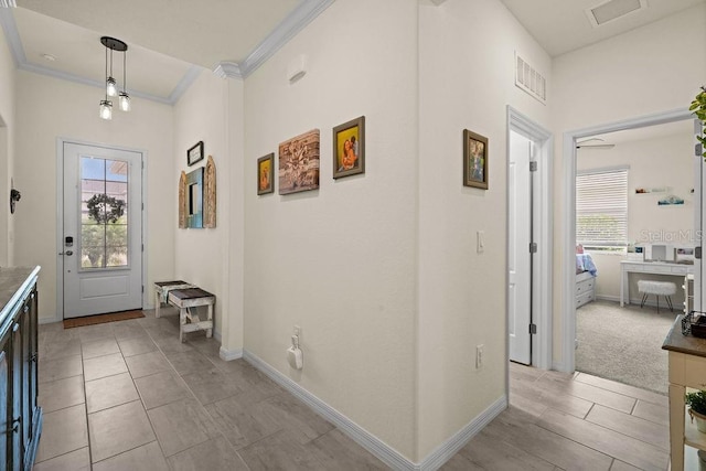 carpeted entrance foyer with a healthy amount of sunlight and ornamental molding