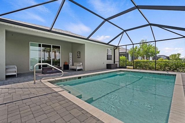 view of pool featuring glass enclosure and a patio area