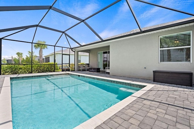 view of pool featuring glass enclosure and a patio