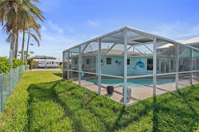 rear view of house with a lanai and a yard