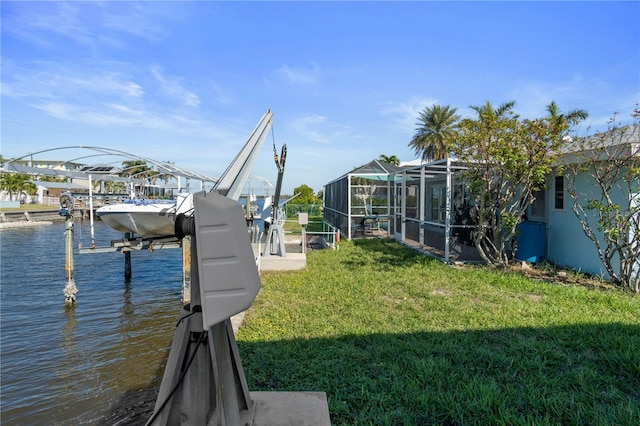 dock area with a lanai, a water view, and a yard