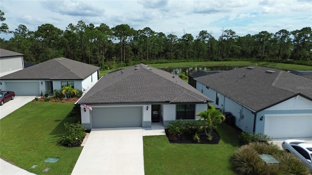 view of front facade with a water view, a front yard, and a garage