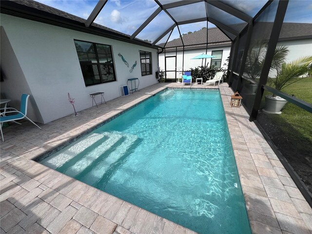 view of swimming pool with a lanai and a patio