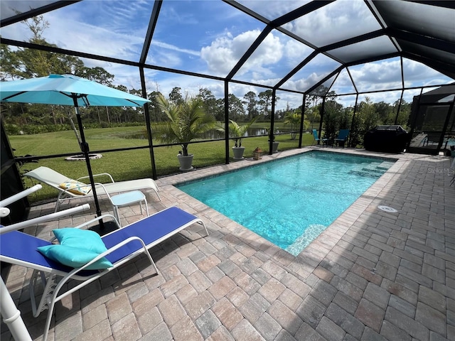 view of pool with glass enclosure, a patio area, and a lawn