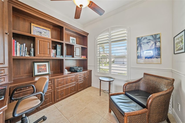 office area with built in desk, light tile patterned floors, ornamental molding, a ceiling fan, and baseboards