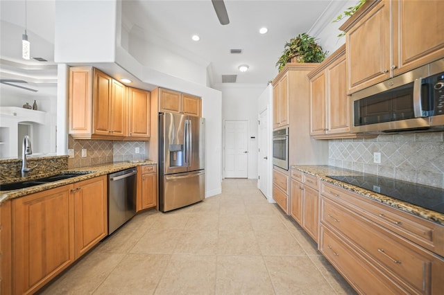 kitchen with stone counters, ceiling fan, stainless steel appliances, and a sink