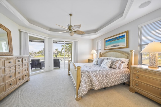 carpeted bedroom featuring access to outside, a raised ceiling, and ceiling fan