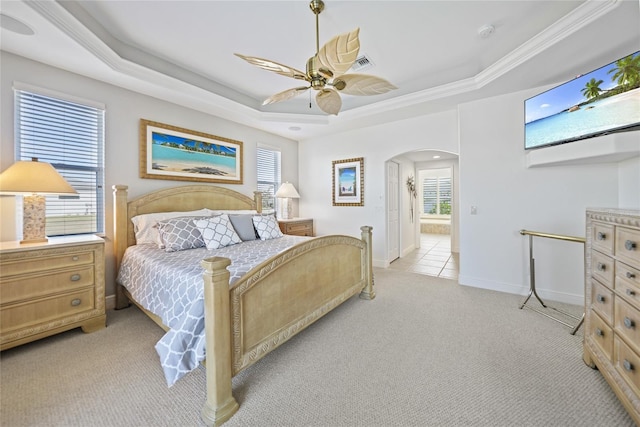 bedroom featuring arched walkways, a tray ceiling, light carpet, and visible vents