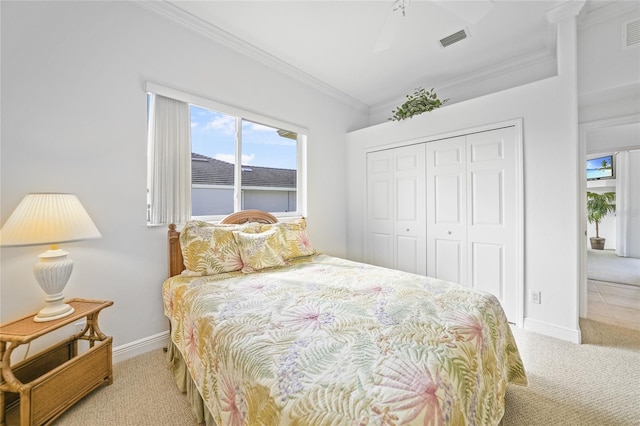 bedroom with ceiling fan, carpet floors, ornamental molding, and a closet