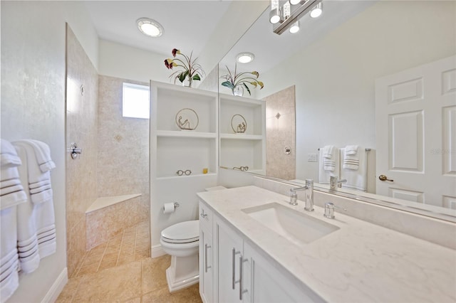 bathroom with tile patterned flooring, vanity, tiled shower, and toilet