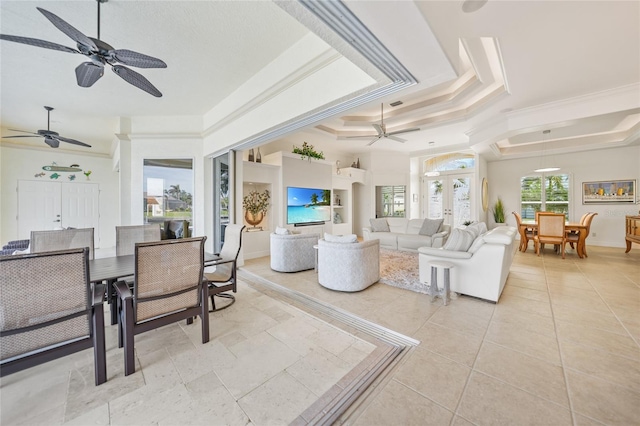 tiled living room with a tray ceiling, crown molding, and french doors