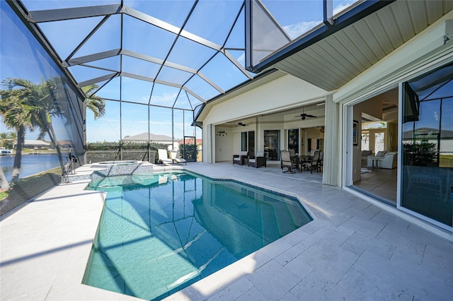 view of pool featuring ceiling fan, a lanai, a water view, a pool with connected hot tub, and a patio area