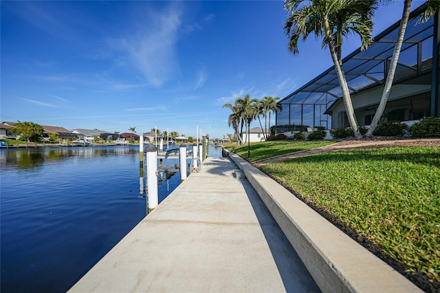 dock area with glass enclosure, a yard, and a water view