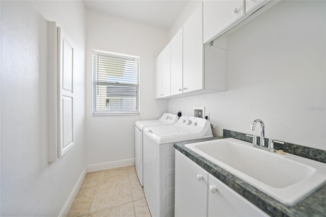 laundry room featuring cabinet space, baseboards, independent washer and dryer, a sink, and light tile patterned flooring