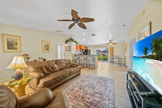 tiled living room featuring ceiling fan and vaulted ceiling