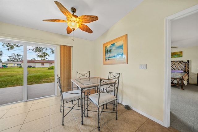 tiled dining space with vaulted ceiling and ceiling fan